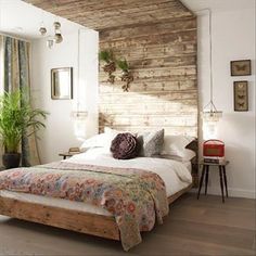 a bed sitting in a bedroom next to a wooden headboard and window sill