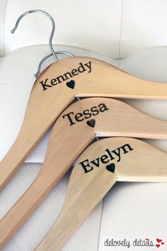 three wooden clothes hangers with names on them