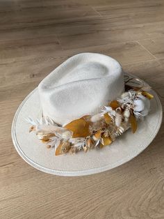 This hat was made in Mexico and adorned in Germany by hand with a dried flowers crown, a matching tassel on the back and a black satin lining inside to complete this unique hat for you.  FEATURES: - Style: Fedora with stiff wide frim - Dimensions: Crown 10.5cm / Brim 8.5 cm - Elastic band inside - Each hat includes a protective bag Handmade Hats With Structured Crown For Kentucky Derby, Handmade Structured Crown Hat For Kentucky Derby, Cream Fedora Hat For Garden Party, Handmade White Hat For Kentucky Derby, Cream Hats For Kentucky Derby Festival, White Wide Brim Bohemian Mini Hats, White Bohemian Felt Hat For Kentucky Derby, Handmade Cream Fedora With Short Brim, Handmade Beige Hats For Garden Party