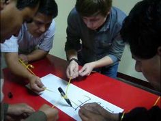 four men are looking at something on a piece of paper