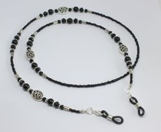 Beautiful black beaded glasses chain.  Made using tiny black glass beads and black glass pearls and crystals with focal Celtic swirl design beads.  The glasses chain is finished with rubber ends to securely attach your glasses.  Please choose desired length from the drop-down menu. Presented in an organza pouch.  Lovely and useful gift idea. Elegant Black Metal Glasses Chains, Black Metal Glasses Chain With Adjustable Feature, Black Metal Glasses Chains With Adjustable Chain, Black Metal Glasses Chain With Adjustable Length, Black Metal Adjustable Glasses Chain, Adjustable Black Metal Glasses Chains, Beaded Metal Glasses Chains As Gift, Metal Beaded Glasses Chains As Gift, Metal Beaded Glasses Chains For Gifts