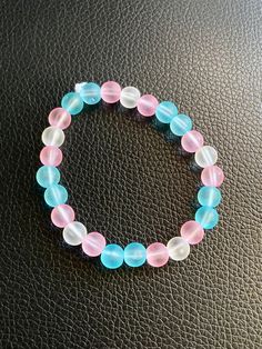 Hand-beaded bracelet with pink and blue plastic beads. This bracelet is strung on an elastic cord.  8" circumference Pink Stretch Bracelet With 8mm Beads, Adjustable Blue Plastic Stretch Bracelet, Pink Beaded Plastic Bracelets, Pink Plastic Round Bead Jewelry, Pink Plastic Round Beads Jewelry, Pink Hand-strung Stretch Bracelet, Casual Pink Stretch Bracelet With 8mm Beads, Casual Pink Bracelets With Large Beads, Casual Pink Beaded Bracelet With Large Beads