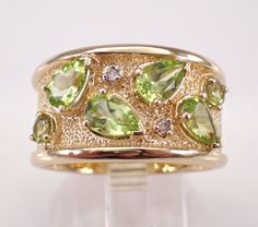 14K Yellow Gold Diamond and Peridot Wedding Anniversary Ring.  This ring is set with two Round Peridot, four Pear shaped Peridot and two Round Brilliant Diamonds.  These Peridot amount to a total weight of 2 1/4 carats.  The diamonds in this ring are H color, I1 clarity and weigh a total of .02 carat. This ring is 14KT Yellow Gold, weighs 8.8 grams, measures 12.5 mm in width and is a finger size 8 3/4, which is resizable (please inquire about sizing with the finger size you need). The ring will be accompanied by an appraisal by a GIA Certified Diamond Grader with the retail replacement value of $3,289.00. I will ship this ring promptly in a gift box. Luxury Peridot Rings For Women, Luxury Peridot Diamond Ring With Accent Stones, Peridot Gemstone Wedding Jewelry, Wedding Jewelry With Peridot Gemstone Accents, Anniversary Peridot Jewelry With Diamond Accents, Wedding Rings With Peridot Gemstone Accents, May Birthstone Jewelry With Single Cut Diamonds For Wedding, Wedding Jewelry With Single Cut May Birthstone Diamonds, Formal Multi-stone Peridot Jewelry