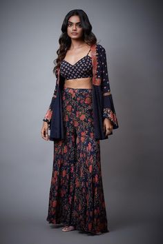 Navy blue tie-up top with floral embroidery and bell sleeves. Paired with printed, embroidered palazzo and blouse.
Component: 3
Pattern: Printed,Embroidered
Type Of Work: Floral
Neckline: Blouse: V neck
Sleeve Type: Top: Bell Sleeves
Fabric: Rayon Crepe
Color: Blue
Other Details: 
Tie-up top
Printed palazzo
Occasion: Sangeet - Aza Fashions Bohemian Palazzo Set With Zari Work, Spring Party Palazzo Set With Printed Motifs, Long Sleeve Blue Anarkali Set With Floral Print, Blue Long Sleeve Floral Anarkali Set, Blue Floral Print Long Sleeve Anarkali Set, Bohemian Long Sleeve Georgette Sets, Bohemian Summer Floral Choli, Summer Bohemian Floral Print Choli, Bohemian Semi-stitched Palazzo Set With Long Sleeves