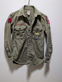 1950-1960s vintage iconic olive green Boy Scouts of America Official Shirt "Sanfordized". The size is work off, so the measurements are below. This shirt was found in Cohocton, NY but is originally from a troop in California. Measurements taken while laying flat: Chest: 17.5" Waist: 17" Length from collar to bottom of shirt: 26" Arm length: 19.5" Free shipping to the US when you spend $35+ in store. Returns accepted within 30 days if the product is not as pictured/described. Happy to send as a gift and gift wrapping is free. I can ship directly to the recipient for you. Just let me know it's a gift. I'm a small shop and offer personalized service, so reach out to me anytime! Thank you for checking out my shop, Rotated Retro. Vintage Green Camp Shirt For Summer, Vintage Camp Shirt With Buttons, Vintage Fitted Camp Collar Shirt, Boy Scout Uniform, Boy Scout Shirt, Boy Scout Patches, Scout Uniform, Vintage Boy Scouts, Boy Scouts Of America