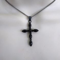 Beautiful in black obsidian and darkly oxidized 925 silver cross necklace! Five black onyx marquise stones at each end of the cross and a center round black onyx in an oxidized gothic style cross.. Marked 925 silver on the back of the cross. Your choice of chain in 16, 18 and 20 inches long. The cross is 1 7/8 inches long and 1 inch wide. Ships out by US Postal Service with insurance included in shipping fee in case of mail loss. Gothic Black Crucifix Cross Necklace, Gothic Black Cross Necklace Gift, Black Cross Pendant Necklace Gift, Black Sterling Silver Cross Necklace, Black Oxidized Pendant Necklaces, Black Cross Necklace As Gift, Black Spiritual Cross Pendant Necklace, Spiritual Black Cross Pendant Necklace, Gothic Black Cross Pendant Necklace