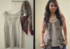 a woman standing in front of a white wall next to a shirt hanging on a hanger