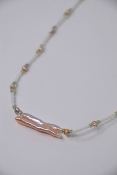 This original ocean themed necklace features a delicate pink biwa pearl on a hand beaded necklace. Biwa pearls are fabulous and no two are alike!  This one is hanging from a hand threaded necklace of pearls, white antique glass beads, and iridescent green glass beads.  Your purchase will come safely wrapped in tissue and ready for presentation in a sheer silk pouch and perfect for the mermaid in your life. Purchase of this (and all items) from VibrantSea will result in 100% of profits going to s Bohemian Pearl Necklace With Pearl Charm, Bohemian Pearl White Necklace With Pearl Charm, Long Beaded Necklace With Pearl Charm, Pearl White Beaded Necklaces For Jewelry Making, Bohemian Pearl Necklace With Pearl Drop, Bohemian Style Pearl Necklace With Pearl Pendant, Bohemian Beaded Baroque Pearl Necklace, Bohemian Pearl Drop Necklace, Adjustable Necklace With Pearl Pendant