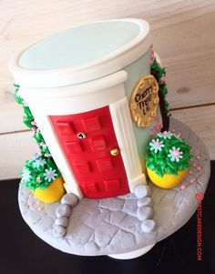 a cake that is shaped like a potted plant and has a red door on it