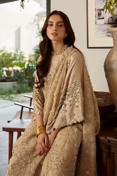 Golden Embellished Pakistani Wedding Dress in Raw Silk is a stylish masterpiece adorned with Hand-crafted details of Sequins, Beads, Sitara, and Motifs. Sequin Chinon Dress For Reception, Glamorous Wedding Traditional Wear With Resham Embroidery, Glamorous Chinon Lehenga For Wedding, Sequin Tissue Silk Traditional Wear For Wedding, Wedding Traditional Wear With Sequins In Tissue Silk, Glamorous Sequined Lehenga In Chinon, Embroidered Fabric With Sequins For Wedding, Glamorous Georgette Dupatta For Wedding, Wedding Lehenga In Raw Silk With Sequins