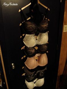 several bras are hanging on a door