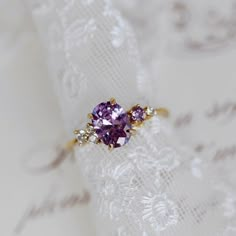 a close up of a ring with a purple stone