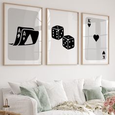 three black and white pictures hanging on the wall above a couch in a living room