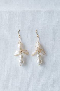 Lynlee earrings are the ultimate accessory to elevate your wedding day style. Featuring beautiful crystal pearls and a lovely lily flower detail, these earrings exude an air of timeless elegance that will draw all eyes to you. DETAILS ❁Handcrafted dip resin flowers with polarized white petals and glossy finish.  ❁Graceful design with dainty Swarovski crystal pearl details. ❁Designed and handmade in Canada. Worldwide shipping. ❁Beautifully gift wrapped in our signature packaging to store your ite White Pearl Drop Clip-on Earrings For Wedding, Elegant Dangle Clip-on Flower Earrings, Elegant Clip-on Dangle Flower Earrings, Pearl White Flower Earrings, Pearl Flower Dangle Earrings For Pierced Ears, Pearl Charm Drop Flower Earrings, Pearl Flower Drop Earrings With Pearl Charm, White Flower-shaped Earrings With Pearl Charm, Formal White Clip-on Flower Earrings