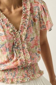 Floral-print crepe blouse. V neckline with smocked ruffle trim. Short bell sleeves. Smocked elastic hem with ruffle. Buttoned keyhole back closure. Relaxed fit. 100% Rayon. Imported. Designed in LA. Model wears size S. Floral Outfit Summer, Ruffle Trim Top, Floral Ruffle Top, Rib Dress, Natural Blush, Crepe Blouse, White Coral, Eye Makeup Tips, Casual Clothes