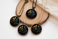 three necklaces with flowers painted on them