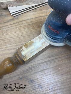 a person using a sander on top of a wooden table