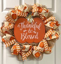 an orange and white wreath that says, thank you and the blessed on it's front door