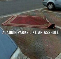 a red rug laying on the ground next to a car