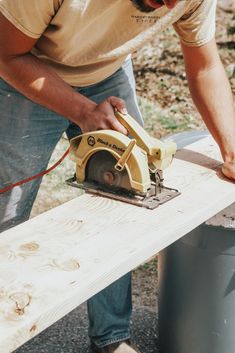 a man using a circular saw to cut planks with a power tool on it