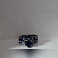 two wedding rings with blue sapphire stones on each one, set in black gold and white gold