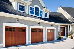 a house with three garage doors and two windows