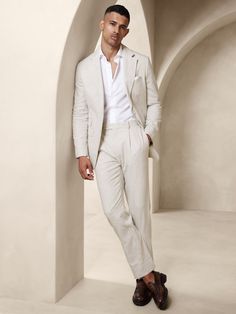 Designed with warm climates in mind, this sleek white suit is cut from an herringbone fabric that blends together soft cotton and luxurious linen.  Here, we left the jacket unlined through the back for even better breathability.  Tailored Slim Fit: More relaxed than our Slim Fit, this Italian cut style has a softer shoulder construction.  Notch lapel with 2-button front.  Four exterior pockets, three interior pockets.  Single back vent.  Lined sleeves, shoulders, and front body, unlined at back. Garden Party Attire, Italy Outfits Men, Linen Suit Men, Mens Linen Suit, Mens White Suit, Wedding Guest Suits, Linen Suits For Men, Suit For Men Wedding, White Linen Suit