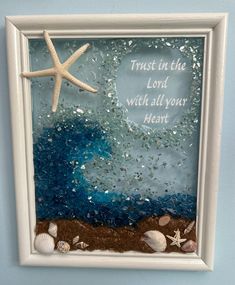 a starfish and seashells in a frame on the wall