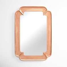 a mirror that is on top of a white wall and it has a small rectangular frame in the middle