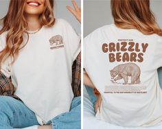 Protect Our Grizzly Bears Comfort Colors T-Shirt, Grizzly Bear Conservation, Animal Conservation Shirt, National Forest Tee, Outdoorsy Shirt { S H I R T / D E T A I L S } These t-shirts are Unisex fit & are Made of pre-shrunk 100% ringspun cotton heather colors are 52% cotton, 48% polyester The Sweatshirts are Unisex fit and are normally 50% cotton and 50% polyester Please see images for sizing details. Please refer to the size chart in the listing photos. ❃ For an oversized look, you may want t Trendy Crew Neck T-shirt With Bear Print, Bear Tshirt Design, Trendy Short Sleeve T-shirt With Bear Print, Cotton Tops With Bear Print And Relaxed Fit, Graphic Tee With Bear Print And Crew Neck, White Graphic Tee With Bear Print, Outdoorsy Shirt, Animal Conservation, Grizzly Bear