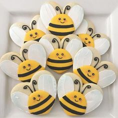 decorated cookies in the shape of bee's on a white plate with black and yellow decorations