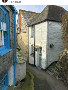 an alley way between two buildings with blue windows