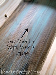 the side of a wooden table with white wash and turquoise paint