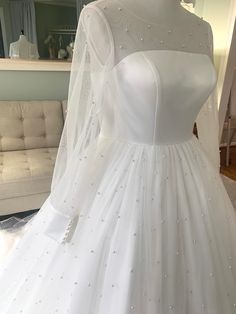 a white wedding dress on display in a room