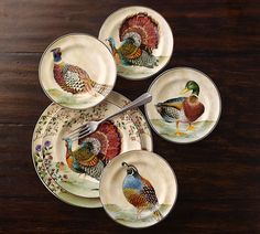 four plates with different colored birds on them and one has a fork in the middle