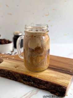 a jar filled with ice cream sitting on top of a wooden cutting board