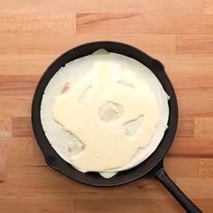 a skillet with some food in it on a wooden table