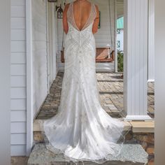 the back of a woman's wedding dress in front of a house