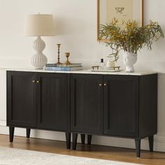 a sideboard with two vases and a lamp on top