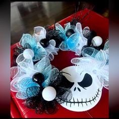 a wreath decorated with black and white decorations on a red tray, sitting on a table