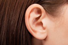 a woman's ear is shown with the top part of her ear pierced in place