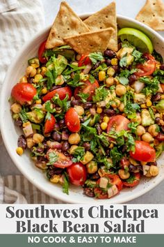 southwest chickpea black bean salad in a white bowl with tortilla chips