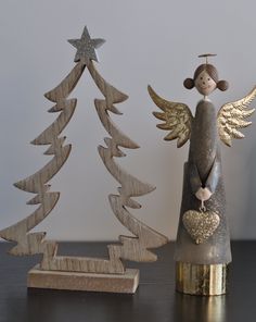 an angel figurine next to a wooden christmas tree