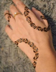 a woman's hand with hennap on it and two rings in the middle