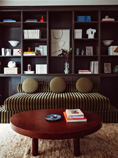 a living room filled with lots of furniture and bookshelves on top of it