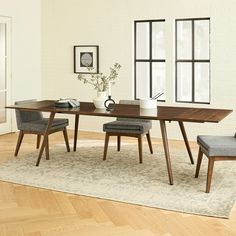 a dining room table with chairs and a rug