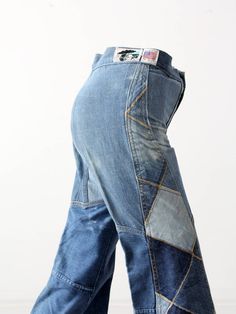 "This is a pair of Antonio Guiseppe designed jeans. The 1970s artist crafted jeans feature a diamond patchwork design of denim. The jeans have a high waist and flared leg. * Antonio Guiseppe * denim patchwork * bell bottoms CONDITION In very good condition. There are spots of faded tone and streaks - this is most likely part of the design. The legs are hemmed with a 1.5\" allowance. MARKED SIZE 28 MEASURED SIZE: 26 x 34 MEASUREMENTS Waist: 26\" ... 66 cm Inseam: 34\" ... 86.4 cm Hips: 33\" ... 8 Retro Patchwork Denim Pants, Retro Denim Patchwork Pants, Retro Wide Leg Patchwork Jeans, Retro Patchwork Medium Wash Bottoms, Retro Medium Wash Patchwork Bottoms, Retro Denim Blue Patchwork Bottoms, Reworked Wide Leg Recycled Denim Bottoms, Vintage Wide Leg Patchwork Jeans, Vintage Reworked Wide Leg Jeans