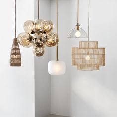 several different types of lights hanging from the ceiling in an empty room with white walls