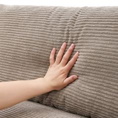 a woman's hand is on the arm of a couch that has been made into a pillow