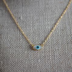 "Protect yo self with our dainty Evil Eye necklace! Our evil eye necklace is cast in sterling 925 silver and plated with yellow gold, complete with a cz stone along the cable chain. The evil eye pendant is made of shell. This dainty evil eye necklace is perfect for everyday wear and makes a thoughtful gift. Comes packaged in a gift box. * S I Z E: - 16\" + 2\" extender chain * ＤＥＴＡＩＬＳ: - Plating: Gold - Evil eye pendant is made of shell. - Ships next business day - Made in Oakville, ON. * C A R Sterling Silver Eye Necklace For Gifts, Dainty Eye-shaped Jewelry For Gift, Dainty Eye-shaped Jewelry Gift, Dainty Gold Eye-shaped Jewelry, Minimalist Eye-shaped Jewelry Gift, Gold Evil Eye Necklace, Necklace Evil Eye, Eye Pendant Necklace, Evil Eye Necklace Gold